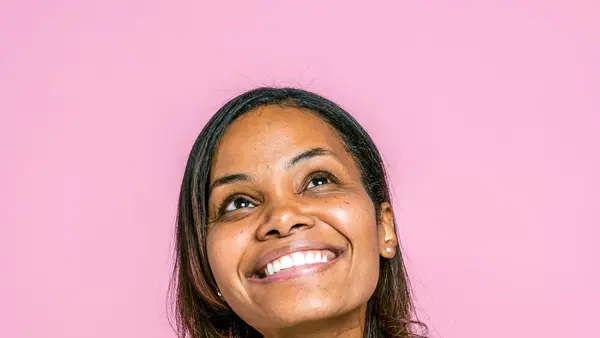 Mulher na faixa dos 40 anos sorrindo — 7 sinais da perimenopausa no cabelo