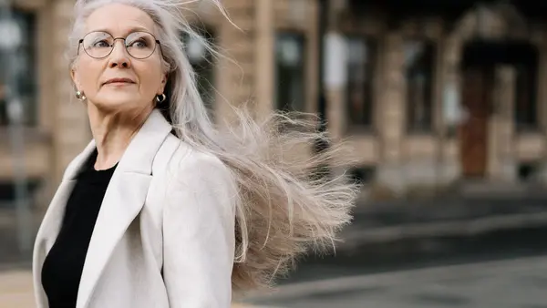 Mulher madura com cabelo ao vento — afinamento capilar depois dos 40