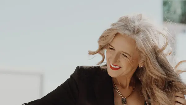 Mulher madura de cabelo grisalho sorrindo — guia de queda de cabelo na menopausa