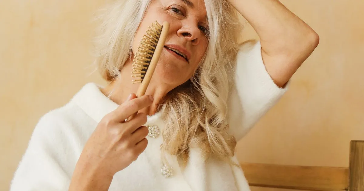 Mulher madura penteando o cabelo — imagem ilustrativa da recuperação capilar após queda por estresse