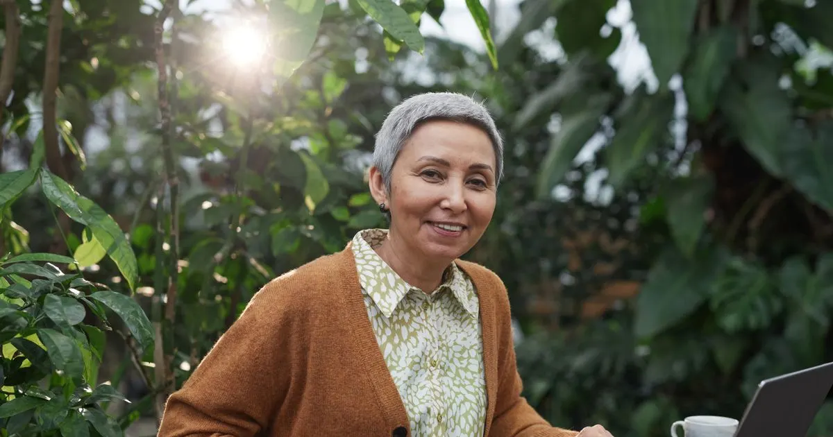 Mulher madura sorridente, cabelo grisalho curto, organizando sua rotina — imagem ilustrativa do artigo sobre a rotina de 30 dias contra a queda de cabelo
