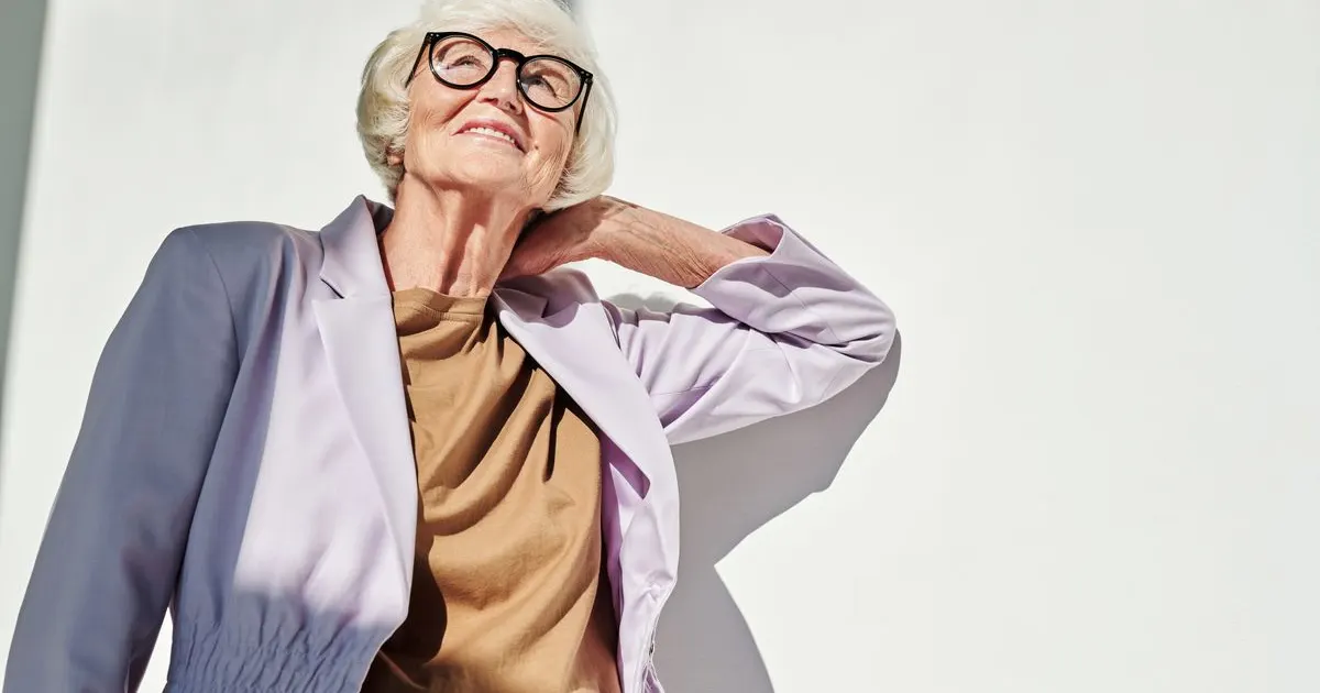 Mulher madura sorrindo com confiança, óculos — imagem ilustrativa do artigo sobre como avaliar suplementos capilares